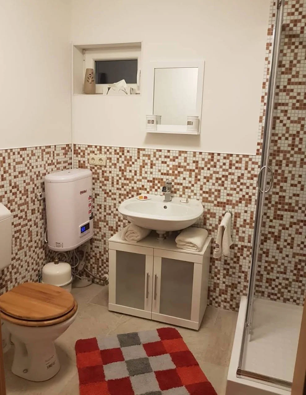 Eigenes Bad mit Dusche und Mosaikfliesen in der Wohnung Kiefer